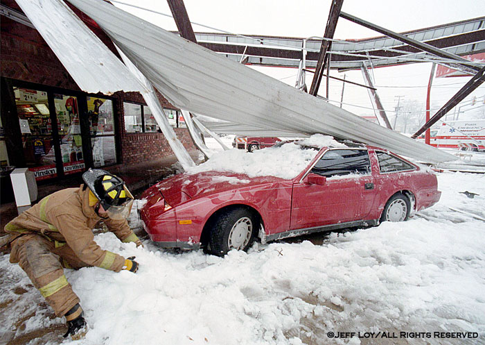Paris, Texas firefighter Daniel Frey digs out a car that was underneath a gas station awning that collapsed under the weight of snow.