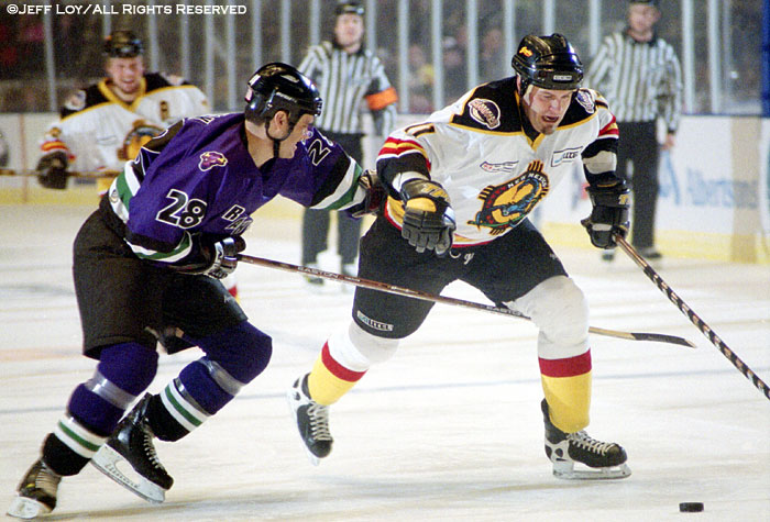 Fort Worth Brahmas defenseman Mike Rusk (#28) tries to beat New Mexico Scorpions right wing Peter Brearley (#11) to the puck.